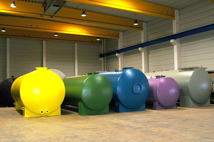 fünf in der Halle der Firma Tank und Apparate Barth GmbH liegende, bunte, gebrauchte DIN-Tanks zur Lagerung von wassergefährdenden Flüssigkeiten. 
