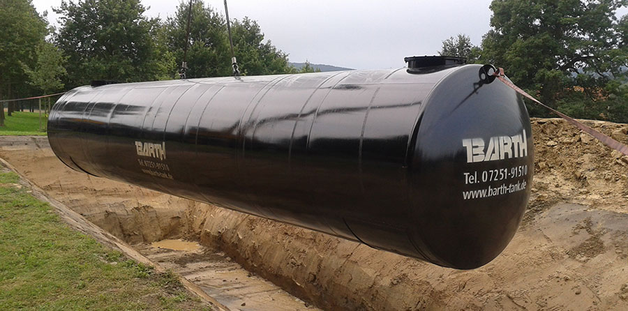 Schwarz beschichteter, unterirdischer Löschwassertank während des Erdeinbaus, am Kran hängend, Wassertank von Firma Tank und Apparate Barth GmbH