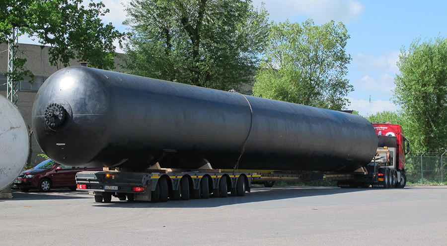 auf Tiefbett liegender, schwarzer unterirdischer Regenwasser Lagerbehälter mit 170.000 Liter Volumen; Fahrzeug verlässt Lagerplatz der Firma Tank und Apparate Barth GmbH